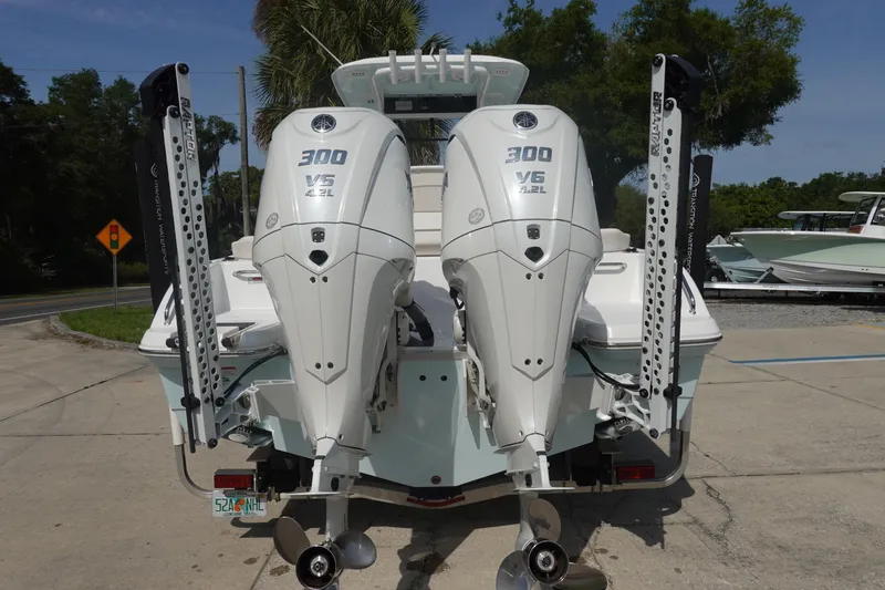 Slide: The Image of 2023 Sea Hunt Escape 28 boat with twin 300 V6 engines, parked outdoors. - 5