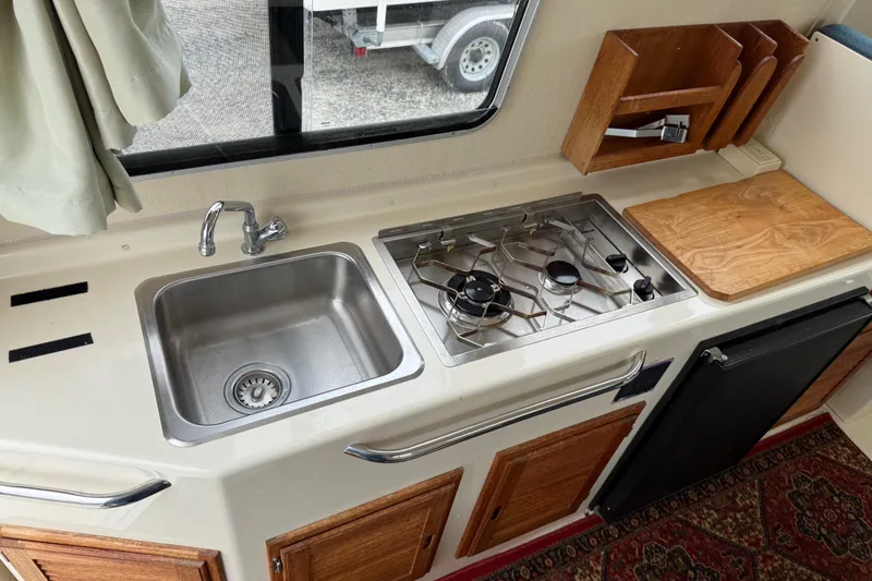 Slide: The Image of Compact kitchen in 2008 Rosborough RF-246 Sedan Cruiser with sink, stove, and wooden cabinetry. - 12