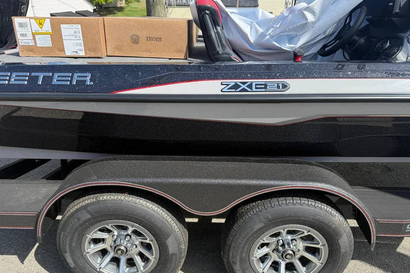 Slide: The Image of 2026 Skeeter ZXE21 boat on trailer with cardboard boxes on deck. - 13