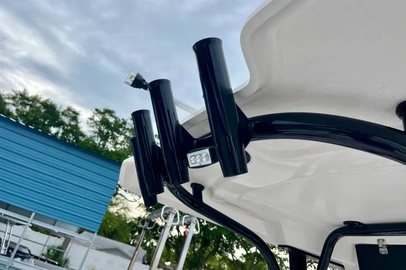 Slide: The Image of 2024 Robalo R230 Center Console boat with rod holders and canopy detail. - 10