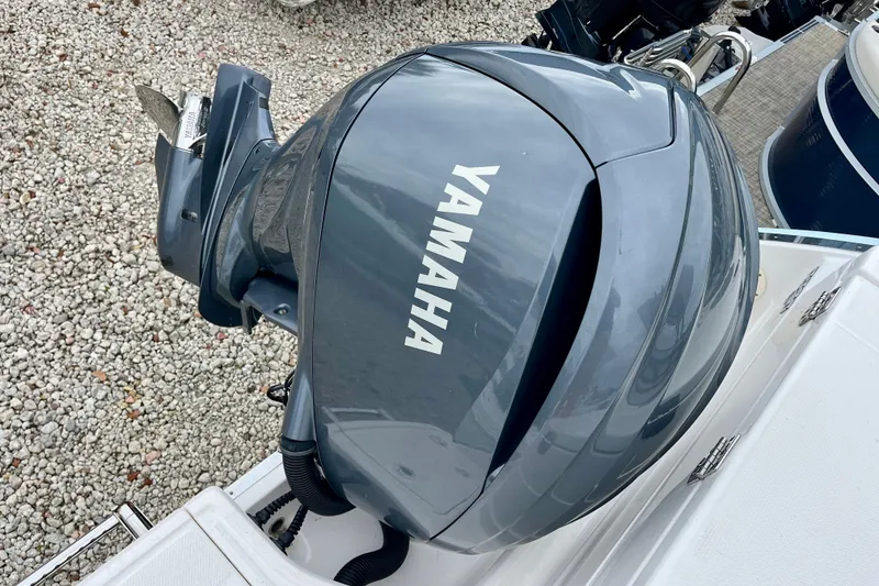 Slide: The Image of 2024 Robalo R230 Center Console with Yamaha outboard motor, on gravel surface. - 14
