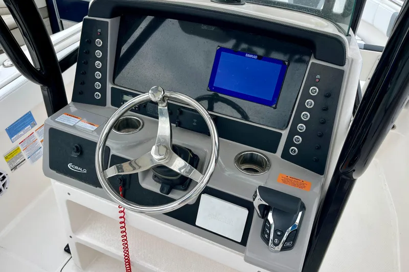 Slide: The Image of 2024 Robalo R230 Center Console boat dashboard with steering wheel and control panel. - 19