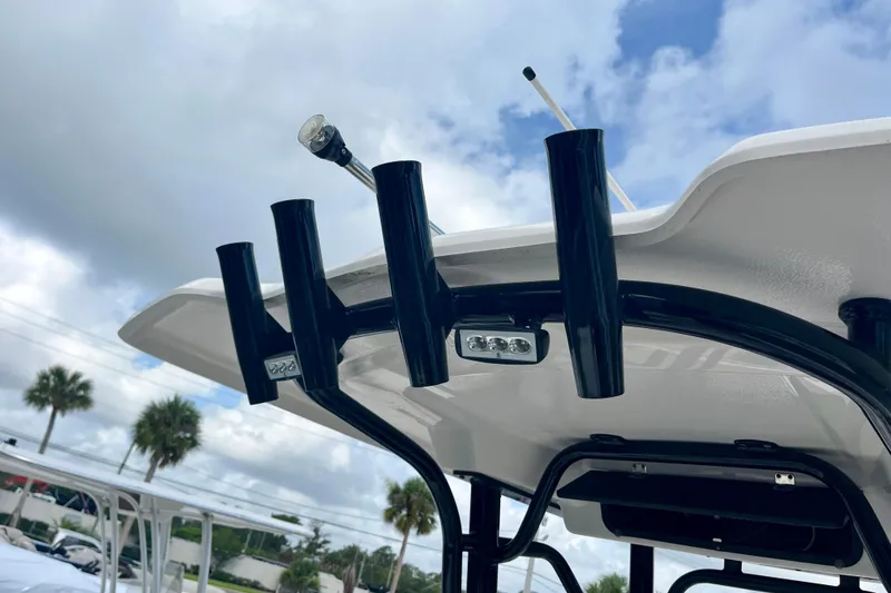 Slide: The Image of Robalo R230 Center Console 2025 with rod holders and sky view. - 25
