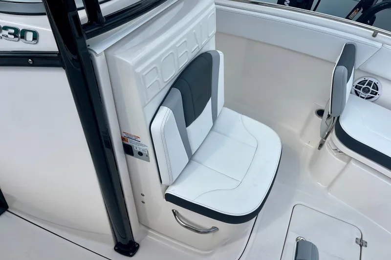 Slide: The Image of 2025 Robalo R230 Center Console boat seating area with white and gray upholstery. - 30