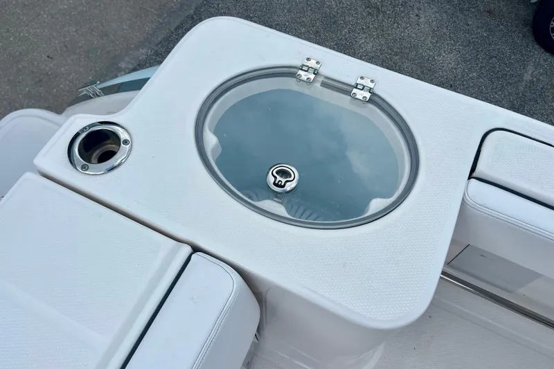 Slide: The Image of 2025 Robalo R230 Center Console boat's livewell and cup holder on deck. - 32
