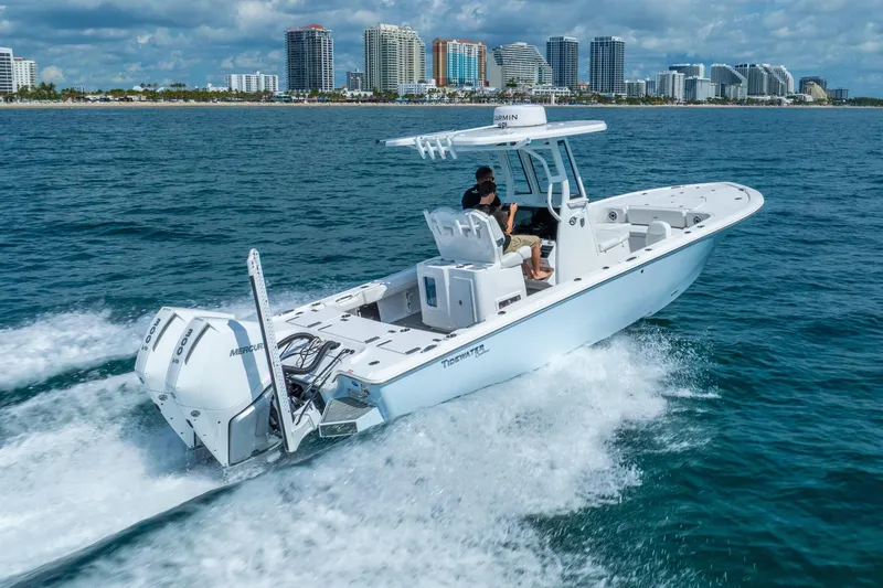 Slide: The Image of 2026 Tidewater 2700 Carolina Bay boat cruising on ocean near city skyline. - 10