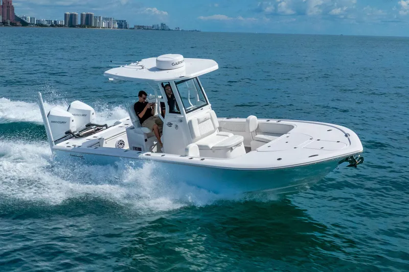 Slide: The Image of 2026 Tidewater 2700 Carolina Bay boat cruising on open water, featuring dual Mercury engines. - 16