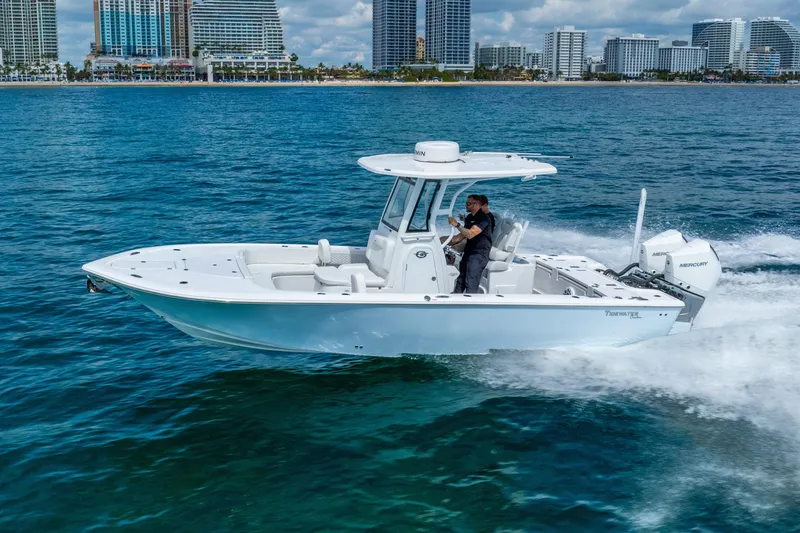 Slide: The Image of 2026 Tidewater 2700 Carolina Bay boat cruising on blue ocean near city skyline. - 19