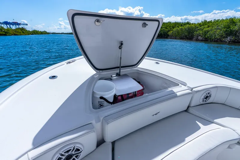 Slide: The Image of 2026 Tidewater 2700 Carolina Bay boat with open storage compartment on calm water. - 24