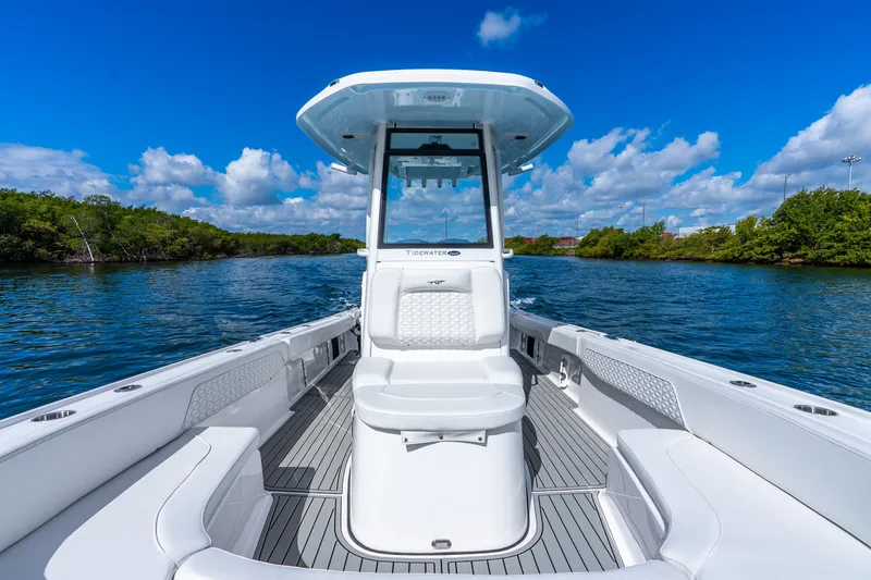 Slide: The Image of 2026 Tidewater 2700 Carolina Bay boat on a scenic waterway under a clear blue sky. - 27