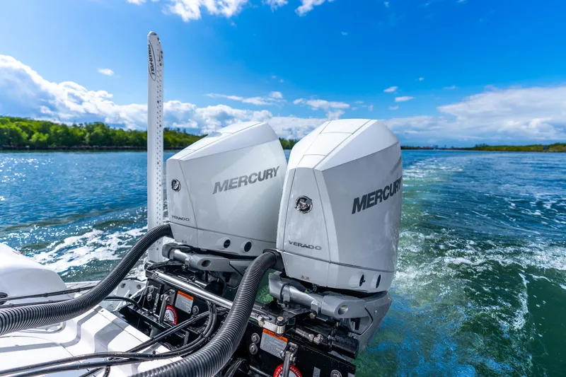 Slide: The Image of Twin Mercury Verado engines on a 2026 Tidewater 2700 Carolina Bay boat, cruising on clear waters. - 33