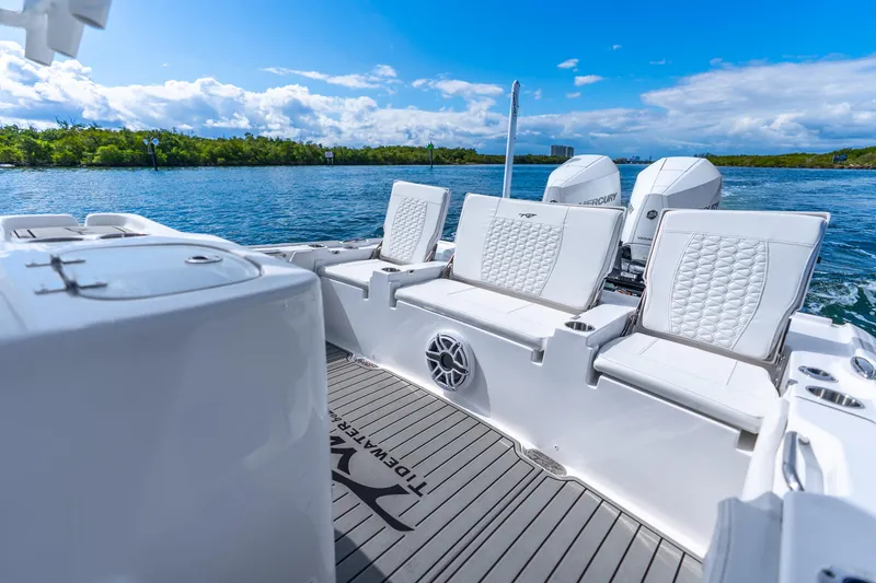 Slide: The Image of 2026 Tidewater 2700 Carolina Bay boat interior with white seating and dual engines on a sunny day. - 36