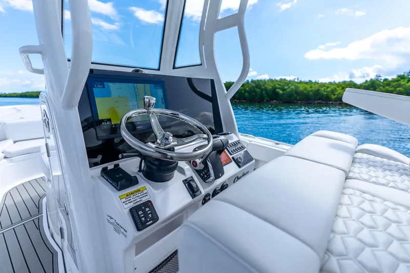 Slide: The Image of 2026 Tidewater 2700 Carolina Bay boat dashboard with steering wheel and navigation screen. - 42