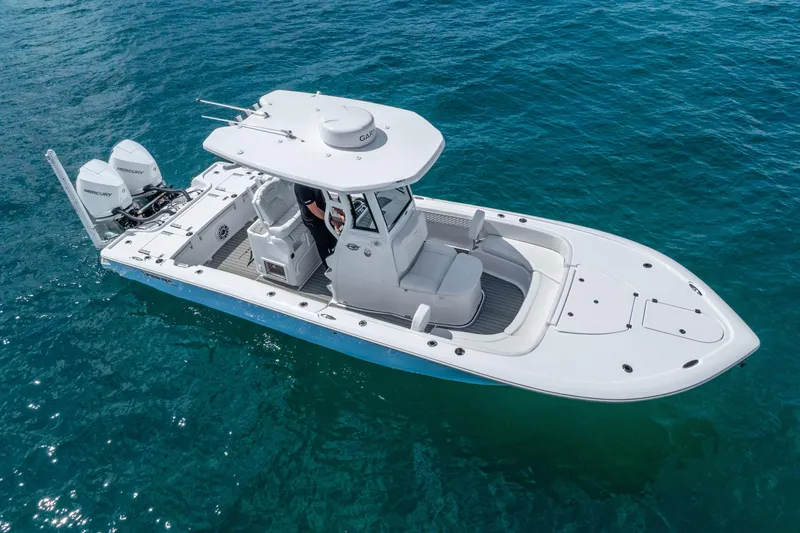 Slide: The Image of 2026 Tidewater 2700 Carolina Bay boat on clear blue water, featuring dual Mercury engines. - 7