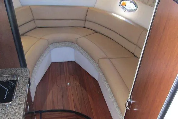Slide: The Image of Luxurious interior of 2024 Crownline 310 CRX boat with plush seating and wood flooring. - 11
