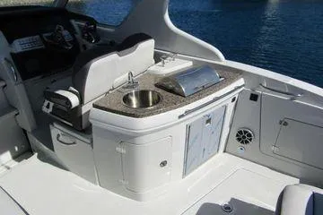 Slide: The Image of 2024 Crownline 310 CRX boat interior with kitchenette and steering area. - 14