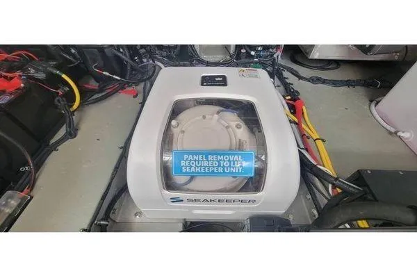 Slide: The Image of Seakeeper unit in 2024 Crownline 310 CRX boat engine compartment, with panel removal notice. - 16