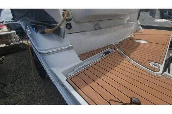 Slide: The Image of 2024 Crownline 310 CRX boat with sleek wooden deck and modern design. - 2