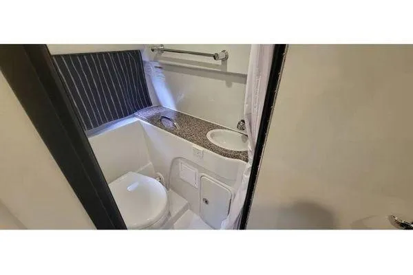 Slide: The Image of 2024 Crownline 310 CRX boat bathroom with modern fixtures and compact design. - 5