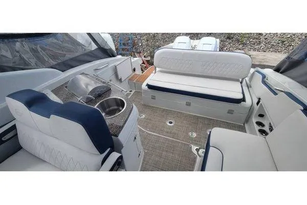 Slide: The Image of 2024 Crownline 310 CRX boat interior with seating and kitchenette area. - 6