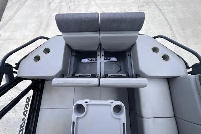 Slide: The Image of 2022 Seadoo Switch interior with gray seating, cup holders, and storage compartments. - 12
