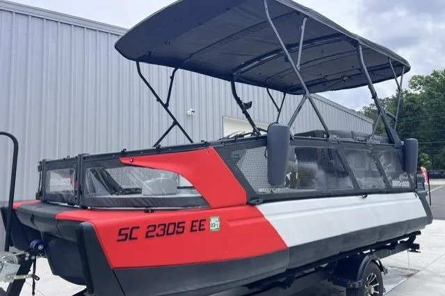 Slide: The Image of 2022 Seadoo Switch boat with canopy, parked near a metal building. - 14