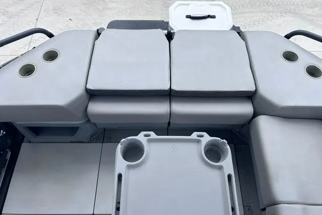 Slide: The Image of 2022 Seadoo Switch boat interior with cushioned seating and cup holders. - 22