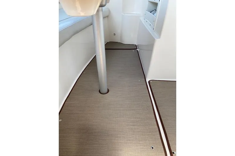 Slide: The Image of 2005 Rinker Fiesta Vee 320 interior with beige flooring and white seating. - 10