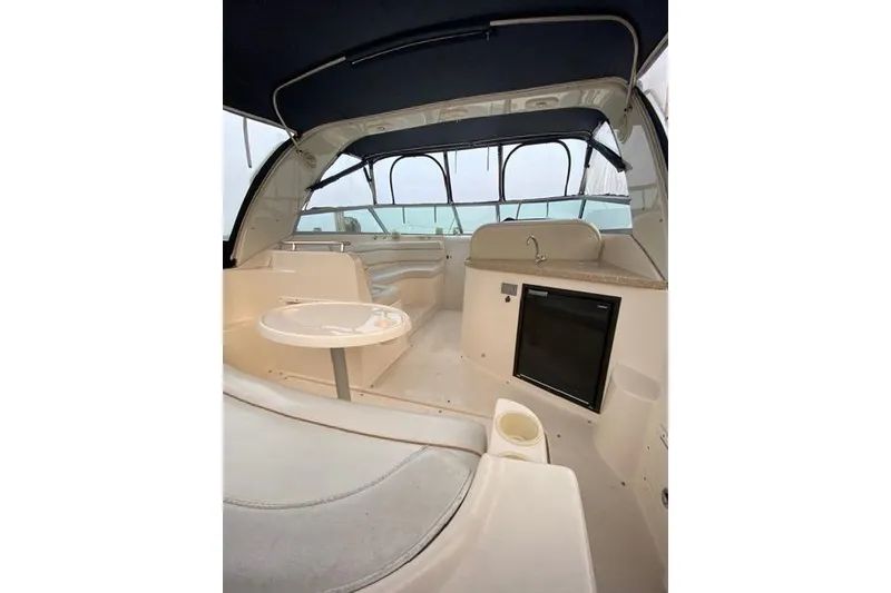 Slide: The Image of 2005 Rinker Fiesta Vee 320 boat interior with seating, table, and kitchenette. - 11