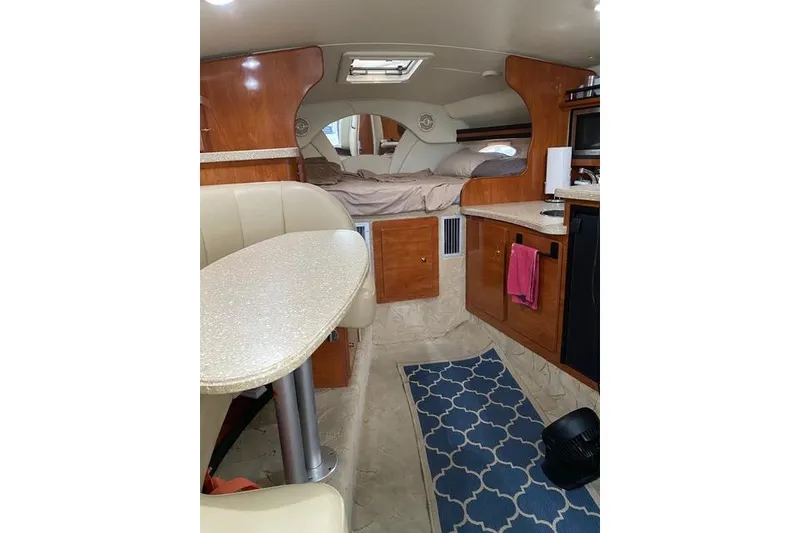 Slide: The Image of 2005 Rinker Fiesta Vee 320 cabin interior with dining area and bed. - 17