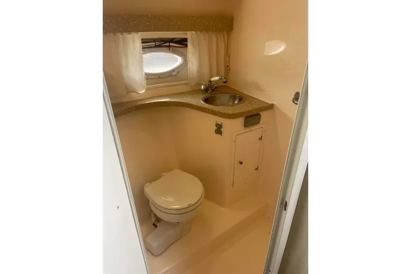 Slide: The Image of 2005 Rinker Fiesta Vee 320 boat bathroom with toilet, sink, and porthole window. - 19