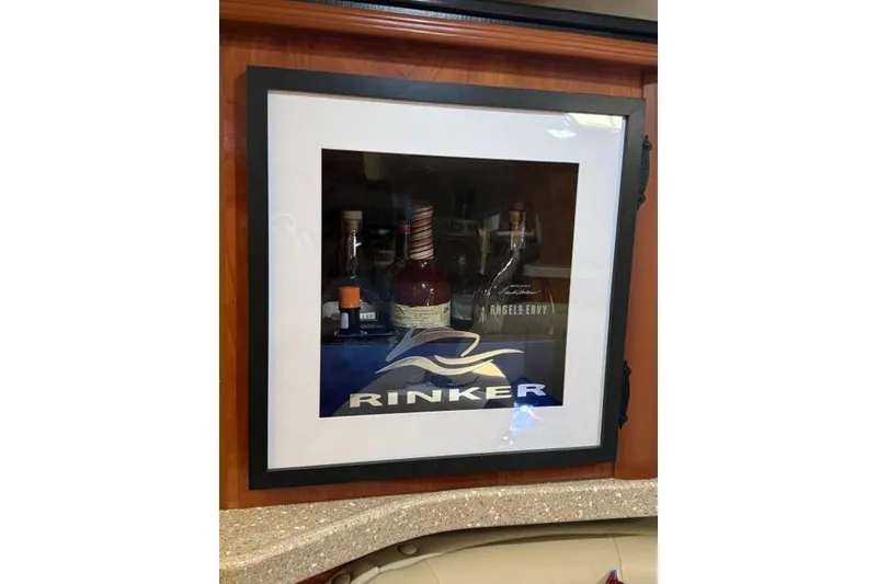 Slide: The Image of Framed Rinker logo with bottles inside a 2005 Rinker Fiesta Vee 320 boat interior. - 20