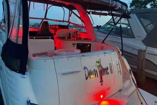 Slide: The Image of 2005 Rinker Fiesta Vee 320 boat docked with red interior lighting at dusk. - 22