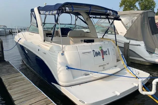 Slide: The Image of 2005 Rinker Fiesta Vee 320 boat docked, featuring blue and white exterior with canopy. - 4