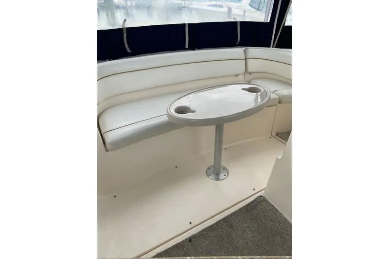 Slide: The Image of 2005 Rinker Fiesta Vee 320 boat interior with white seating and oval table. - 8