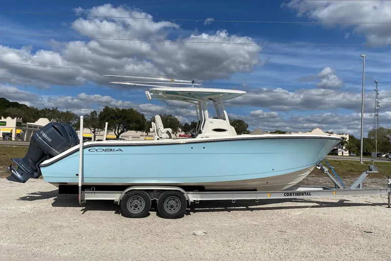 The Image of 2019 Cobia 280 Center Console boat on trailer under blue sky. - 1