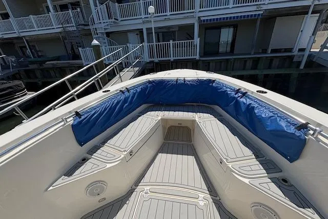 Slide: The Image of 2019 Cobia 280 Center Console boat with blue seating, docked near waterfront homes. - 13