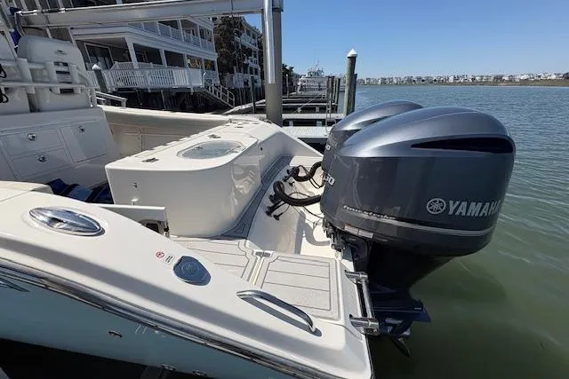 Slide: The Image of 2019 Cobia 280 Center Console boat with dual Yamaha engines docked by waterfront homes. - 16