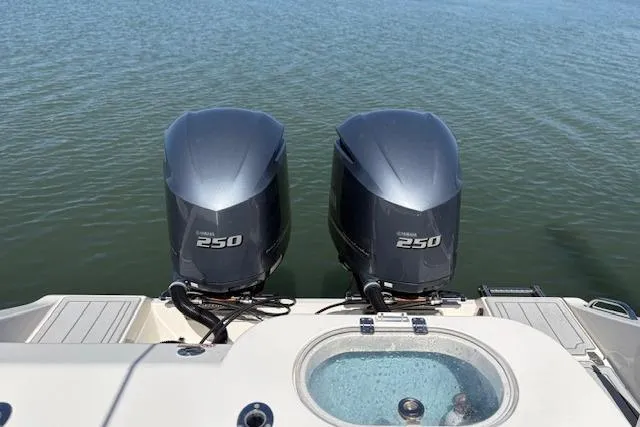 Slide: The Image of 2019 Cobia 280 Center Console with twin Yamaha 250 engines on calm water. - 19