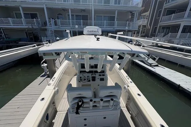 Slide: The Image of 2019 Cobia 280 Center Console boat docked, featuring Garmin equipment and spacious seating. - 21