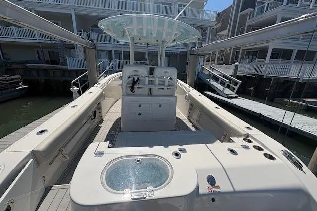 Slide: The Image of 2019 Cobia 280 Center Console boat docked, featuring spacious deck and modern amenities. - 23