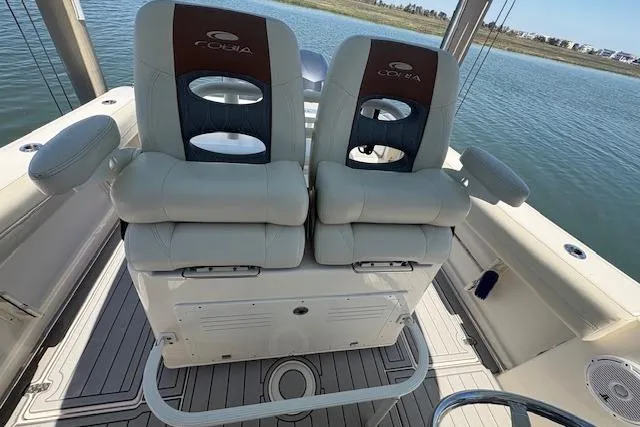 Slide: The Image of 2019 Cobia 280 Center Console boat seats with armrests on a calm water backdrop. - 24