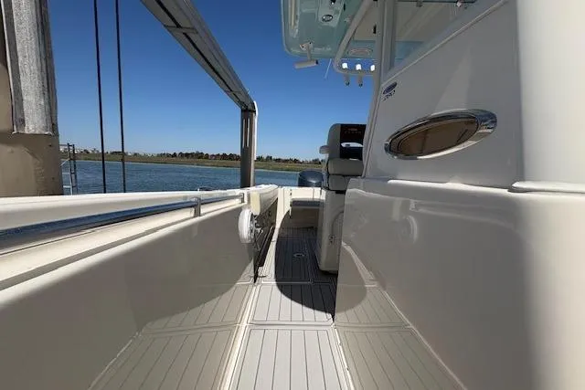 Slide: The Image of 2019 Cobia 280 Center Console boat docked, showcasing sleek design and spacious deck. - 31