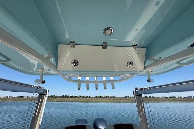 Slide: The Image of 2019 Cobia 280 Center Console boat with rod holders, viewed from below on calm water. - 35