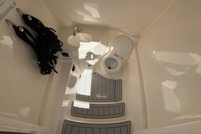 Slide: The Image of 2019 Cobia 280 Center Console boat interior with toilet and storage area. - 39