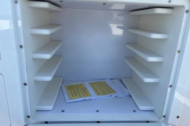Slide: The Image of Storage compartment in a 2019 Cobia 280 Center Console boat with documents inside. - 47