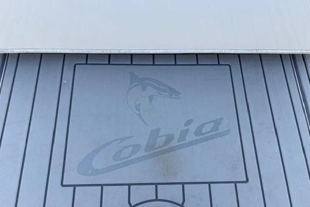 Slide: The Image of 2019 Cobia 280 Center Console boat deck with logo and shark emblem. - 48