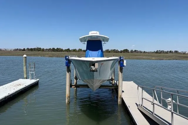 Slide: The Image of 2019 Cobia 280 Center Console boat docked on a lift in a serene waterway. - 7