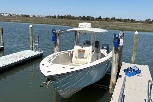 Slide: The Image of 2019 Cobia 280 Center Console boat docked on a lift in a marina. - 8