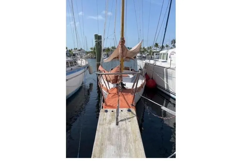 Slide: The Image of Vintage 1939 Alden Cutter sailboat docked at a marina, surrounded by other boats. - 16